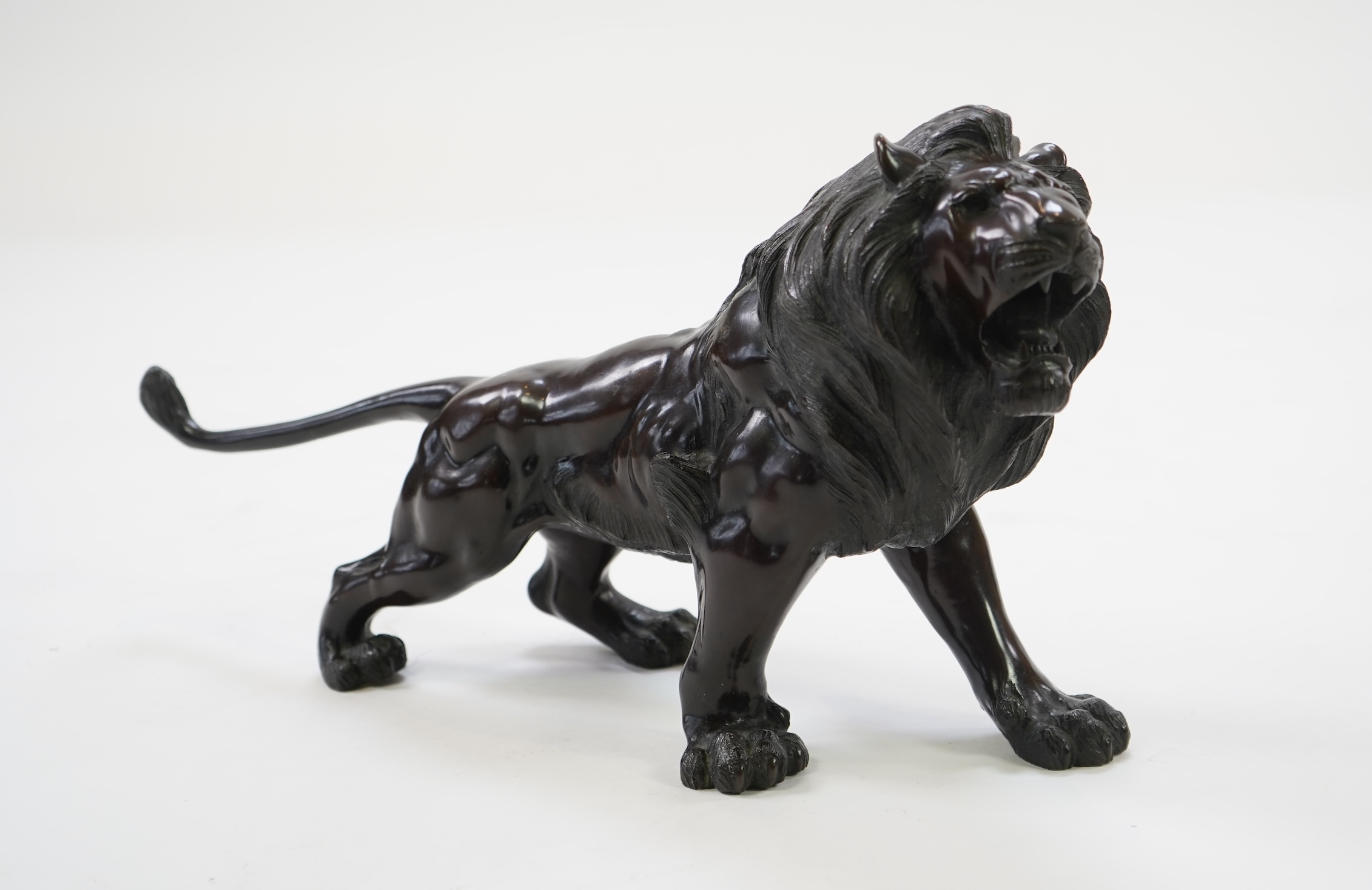 A Japanese patinated bronze okimono of a roaring lion, Meiji period